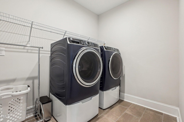 clothes washing area with tile patterned flooring and washing machine and clothes dryer