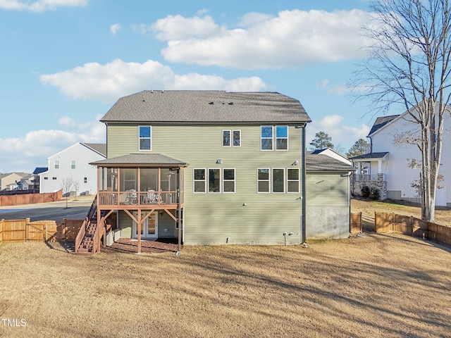 rear view of house featuring a sunroom and a yard