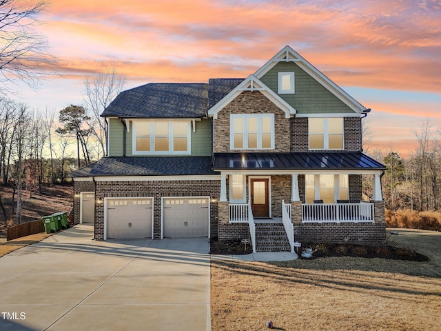 craftsman-style house with a yard, covered porch, and a garage