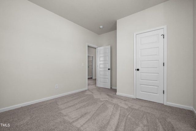 unfurnished bedroom featuring light carpet and a closet