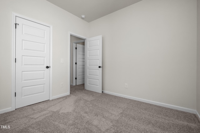 unfurnished bedroom with light carpet and a closet