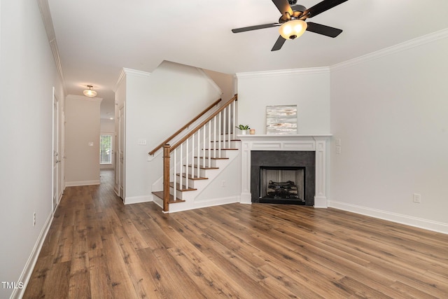 unfurnished living room with hardwood / wood-style floors, ceiling fan, and crown molding