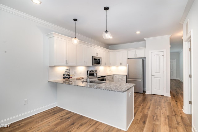 kitchen featuring white cabinetry, stainless steel appliances, backsplash, kitchen peninsula, and decorative light fixtures