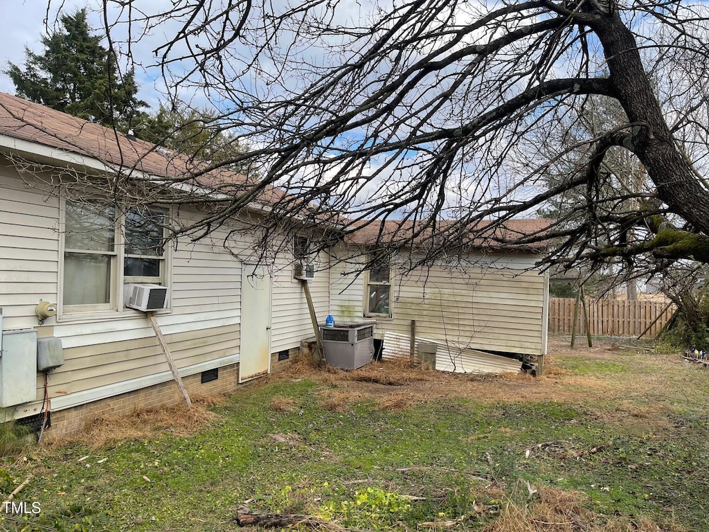 view of property exterior with cooling unit and a lawn