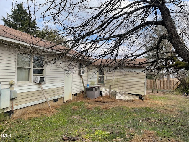 view of property exterior with cooling unit and a lawn