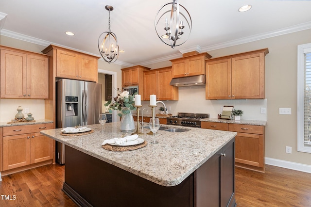 kitchen with light stone counters, a kitchen island with sink, pendant lighting, a notable chandelier, and dark hardwood / wood-style floors