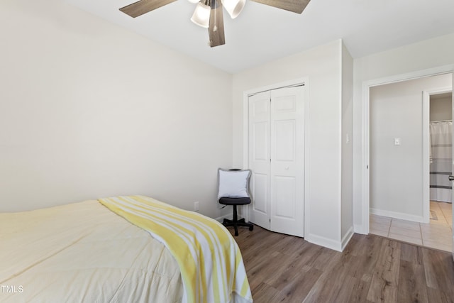 bedroom featuring ceiling fan, light wood-type flooring, and a closet