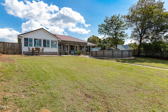 rear view of house with a pergola and a lawn