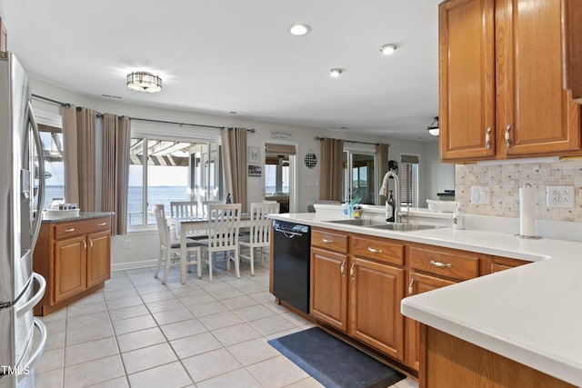 kitchen with dishwasher, backsplash, a water view, sink, and stainless steel refrigerator