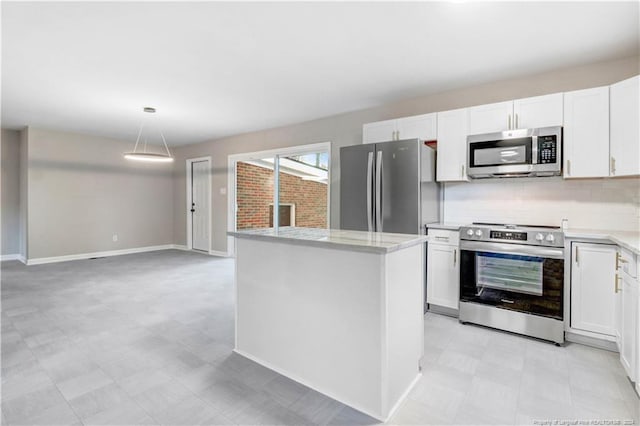 kitchen featuring a center island, white cabinets, decorative backsplash, decorative light fixtures, and stainless steel appliances