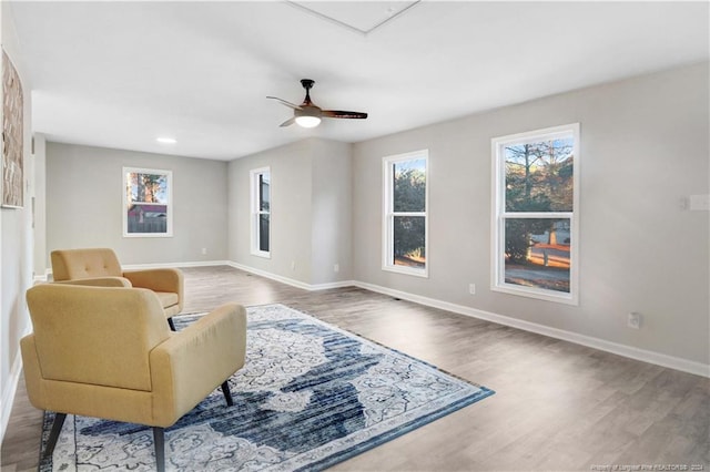 living area with hardwood / wood-style floors and ceiling fan