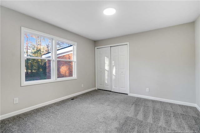 unfurnished bedroom featuring carpet floors and a closet