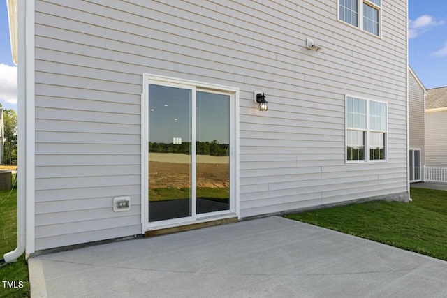 view of home's exterior with a patio and a lawn