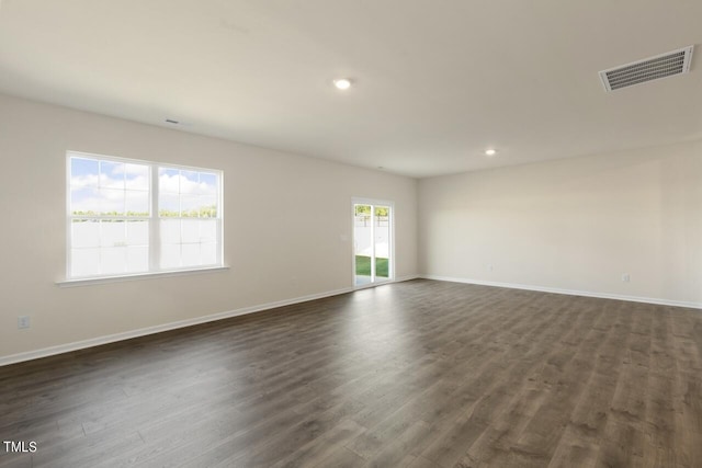 unfurnished room with dark hardwood / wood-style floors and plenty of natural light