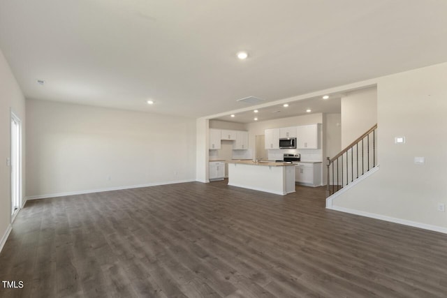 unfurnished living room featuring dark wood-type flooring