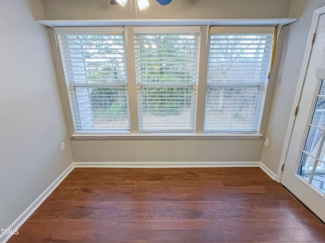 spare room featuring ceiling fan and dark wood-type flooring