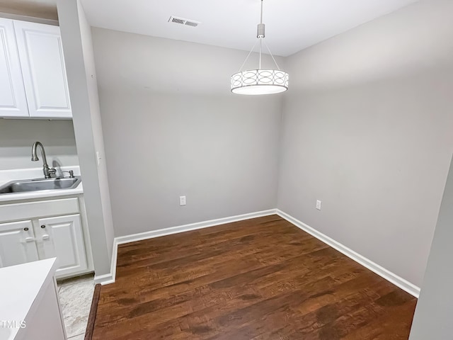 unfurnished dining area with sink and dark wood-type flooring