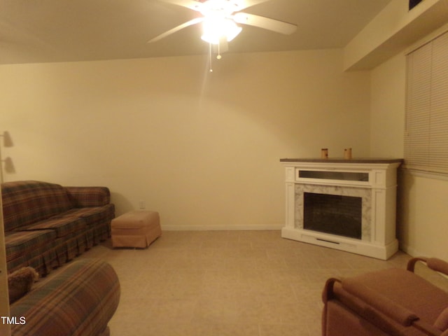 living room with ceiling fan and a premium fireplace