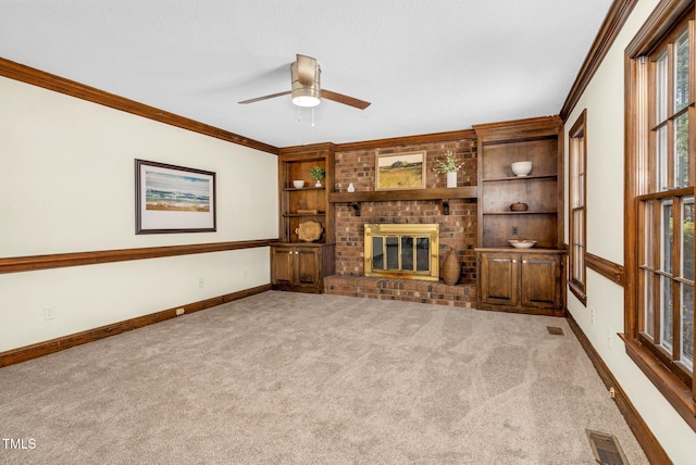 unfurnished living room with light carpet, a brick fireplace, ceiling fan, built in features, and ornamental molding