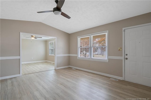 interior space featuring a textured ceiling, ceiling fan, light hardwood / wood-style floors, and lofted ceiling