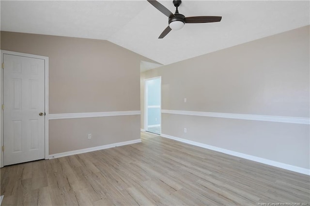 empty room with ceiling fan, light hardwood / wood-style floors, and vaulted ceiling