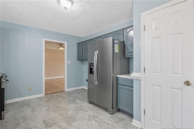 kitchen with stainless steel fridge, a textured ceiling, and ceiling fan