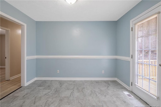 spare room with a textured ceiling