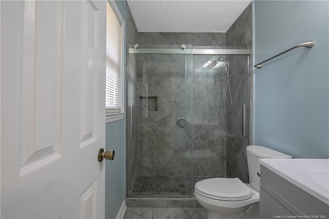 bathroom featuring an enclosed shower, vanity, toilet, and a textured ceiling