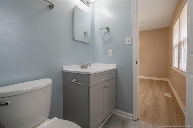 bathroom with vanity, toilet, and wood-type flooring