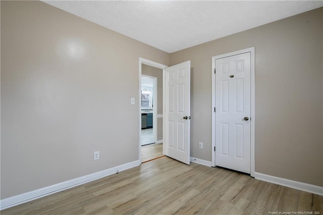 unfurnished bedroom featuring a textured ceiling and light wood-type flooring