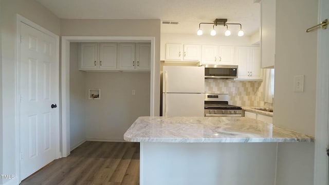 kitchen featuring backsplash, white cabinets, dark hardwood / wood-style floors, light stone countertops, and stainless steel appliances