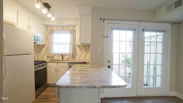 kitchen featuring white cabinetry, sink, stainless steel appliances, tasteful backsplash, and dark hardwood / wood-style flooring