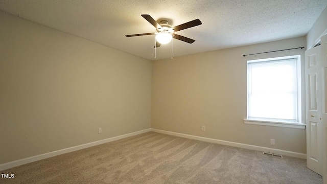 carpeted empty room featuring a textured ceiling and ceiling fan