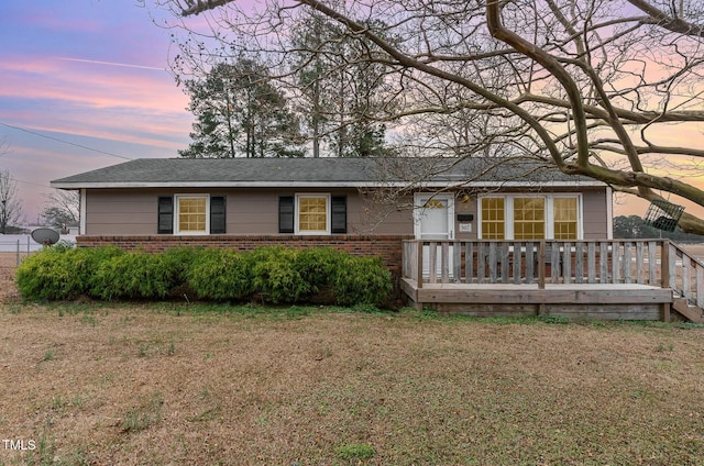 view of front of home with a lawn and a wooden deck