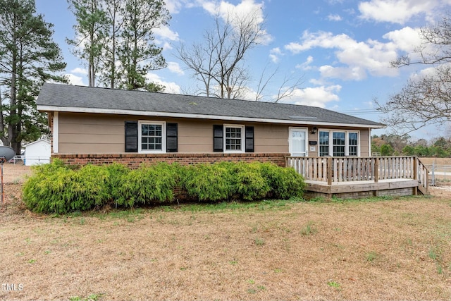 ranch-style home with a front yard and a wooden deck