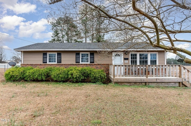 ranch-style home featuring a front yard and a deck