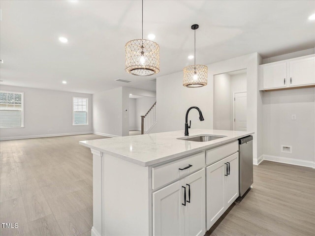 kitchen featuring sink, white cabinetry, light stone counters, hanging light fixtures, and dishwasher