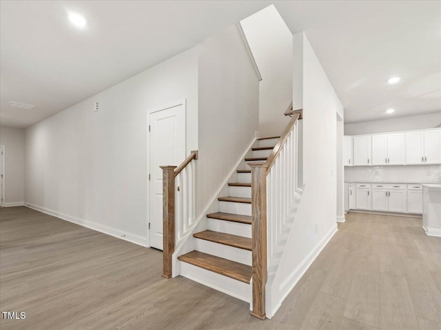 stairs featuring hardwood / wood-style floors