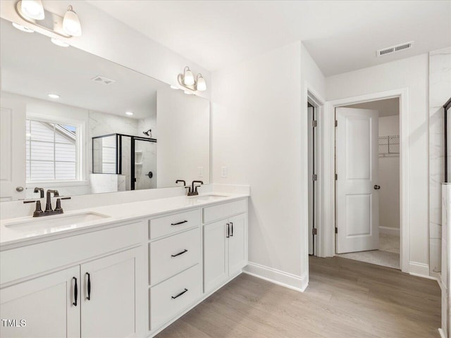 bathroom with vanity, hardwood / wood-style floors, and an enclosed shower