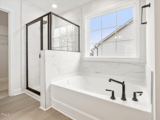 bathroom with shower with separate bathtub and hardwood / wood-style floors