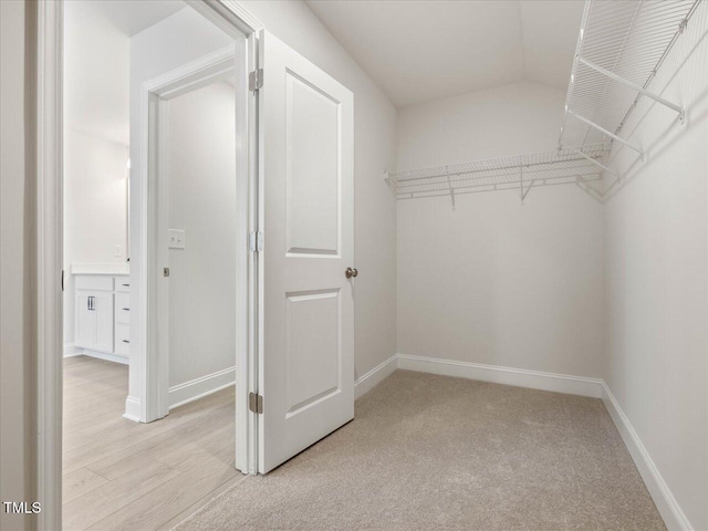 walk in closet featuring light colored carpet