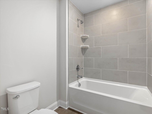 bathroom with tiled shower / bath combo and toilet