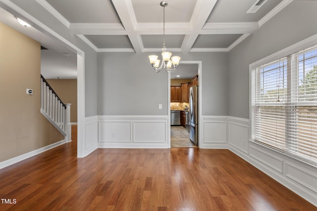 unfurnished dining area with crown molding, a notable chandelier, hardwood / wood-style flooring, beam ceiling, and coffered ceiling