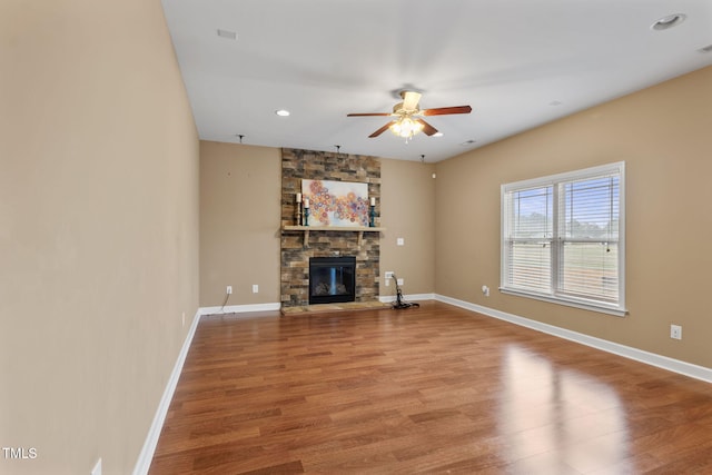 unfurnished living room with hardwood / wood-style flooring, ceiling fan, and a fireplace