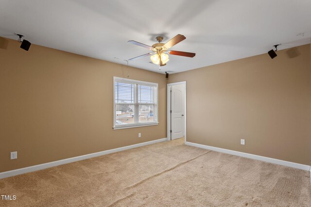 carpeted spare room with ceiling fan