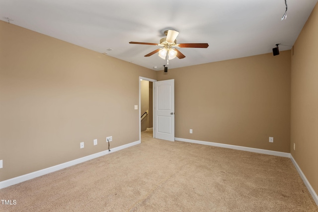 carpeted spare room featuring ceiling fan