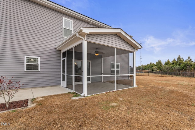 rear view of property with ceiling fan, a lawn, a patio area, and a sunroom