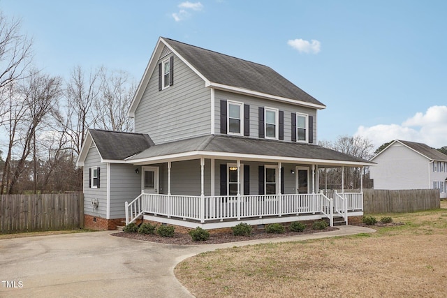 farmhouse featuring covered porch and a front lawn