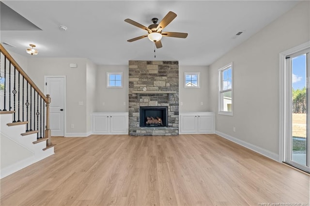 unfurnished living room with a fireplace, light hardwood / wood-style floors, a wealth of natural light, and ceiling fan