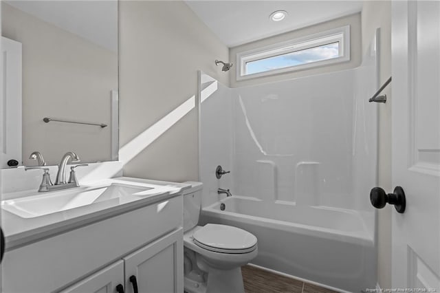 full bathroom with hardwood / wood-style floors, vanity, toilet, and shower / washtub combination